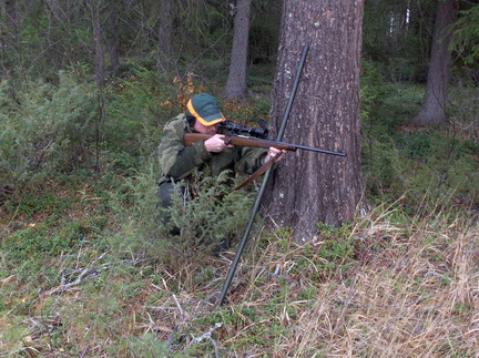 Knlende med skydestok mod tr